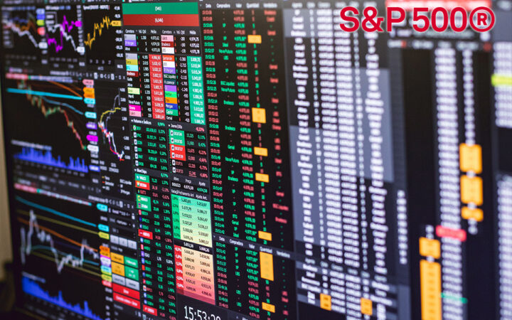 Multiple monitors show dense financial market data: stock charts, color-coded tables, and a large S&P 500® logo in the top-right corner; time stamp at bottom reads 15:53:29.